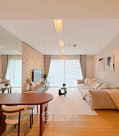 Modern living room with cozy sofa, stylish decor, and large windows offering natural light.