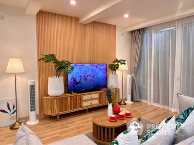 Stylish living room with modern decor and wooden accents, featuring a cozy seating area and large TV.