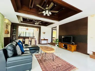 Spacious living room with modern decor and ceiling fans, perfect for relaxation.