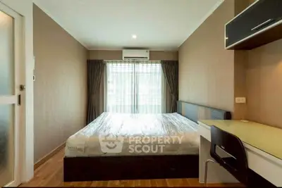 Modern bedroom with large window, sleek furniture, and natural light.