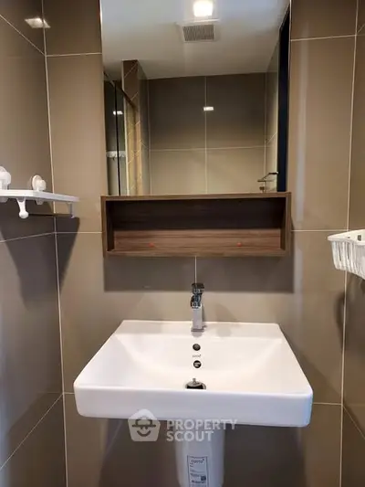 Modern bathroom with sleek sink and wall-mounted shelf in contemporary design.
