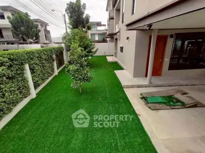 Spacious garden area with lush green lawn and modern building exterior