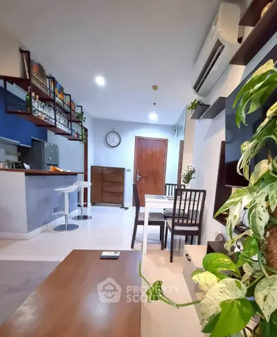 Modern living room with open kitchen, stylish decor, and cozy dining area in a contemporary apartment.