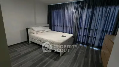 Modern bedroom with sleek flooring and elegant curtains, perfect for a cozy retreat.