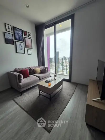 Modern living room with cozy sofa and balcony view in urban apartment.