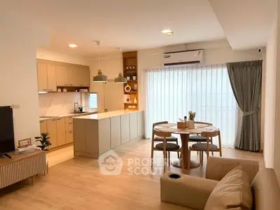 Modern open-layout kitchen and dining area with natural light and stylish decor.