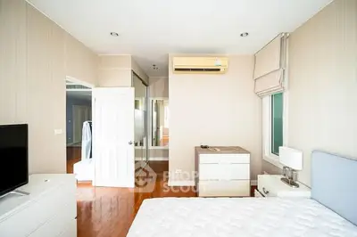 Spacious bedroom with modern decor and ample natural light