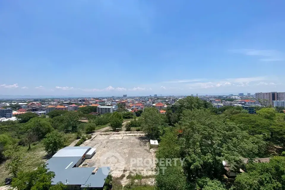 Stunning panoramic city view from high-rise building, showcasing lush greenery and urban skyline.