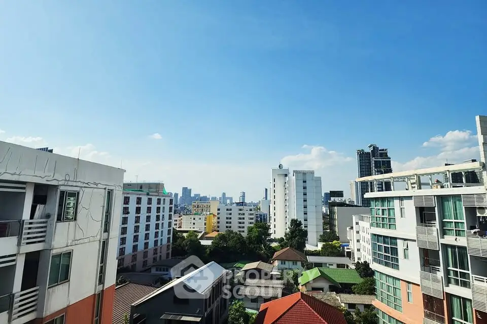 Stunning cityscape view from a high-rise apartment, showcasing modern urban living with clear blue skies.