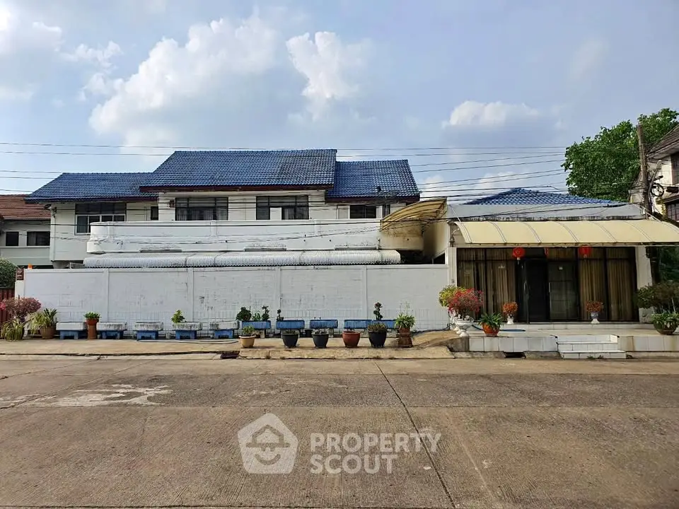 Charming suburban house with blue roof and spacious front yard