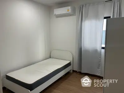 Minimalist bedroom with single bed and air conditioning