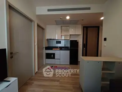 Modern compact kitchen with sleek cabinetry and integrated appliances in cozy apartment.