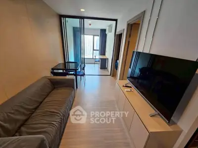 Modern living room with sleek furniture and large TV, featuring a spacious open layout and stylish decor.