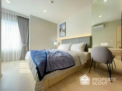 Elegant bedroom with plush bedding, modern furniture, and ample natural light streaming through sheer curtains, perfect for a serene retreat.