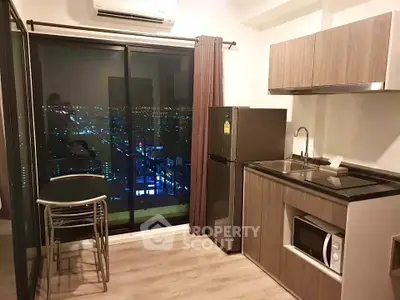 Modern kitchen with city view, featuring sleek cabinetry and compact dining area.