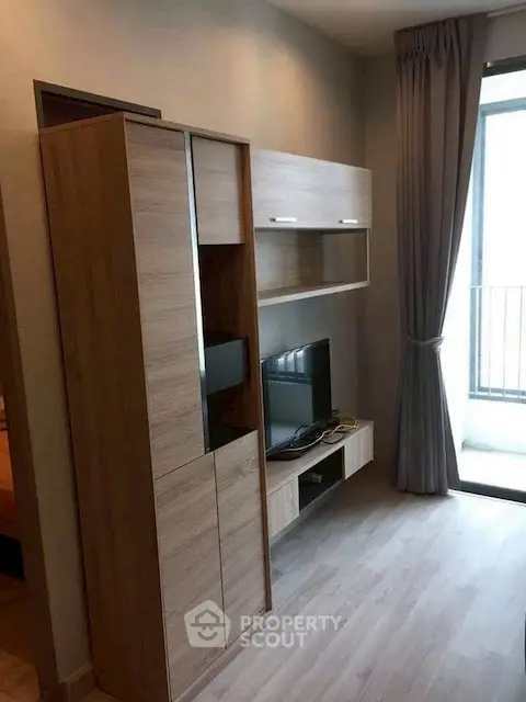 Modern living room with sleek wooden furniture and large window for natural light.