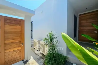 Modern minimalist exterior with wooden doors and lush greenery, showcasing sleek architectural design.