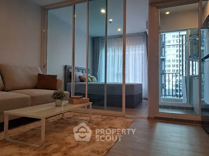 Modern living room with cozy decor and view into a stylish bedroom
