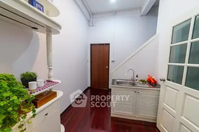 Charming small kitchen with wooden floors and white cabinetry, perfect for cozy cooking experiences.