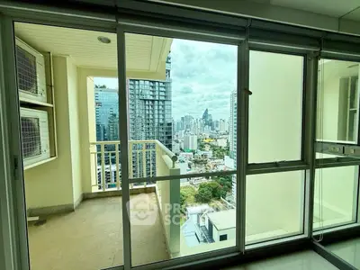 Spacious balcony with stunning city skyline view from high-rise apartment.