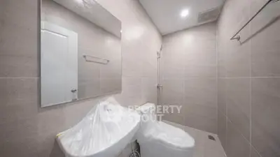 Modern minimalist bathroom with sleek fixtures and neutral tiles, perfect for contemporary living.