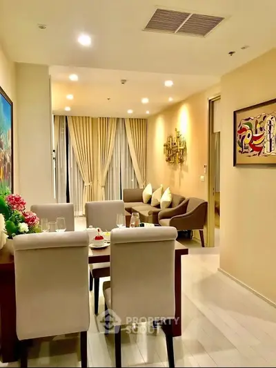 Elegant living room with modern decor and dining area, featuring cozy seating and ambient lighting.