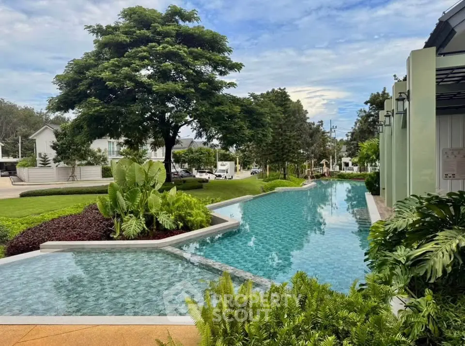 Luxurious outdoor pool surrounded by lush greenery in a serene residential area.