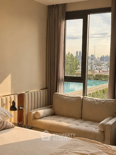 Luxurious bedroom with city view and cozy seating area, perfect for relaxation and comfort.