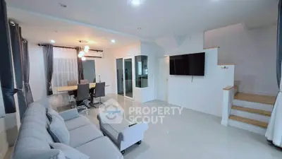 Spacious modern living room with elegant dining area and sleek staircase