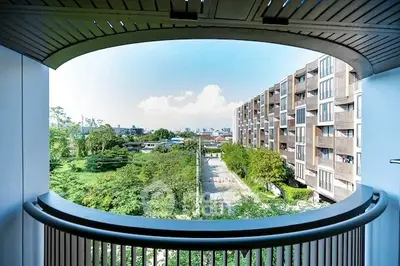 Stunning balcony view overlooking lush greenery and modern apartment buildings.