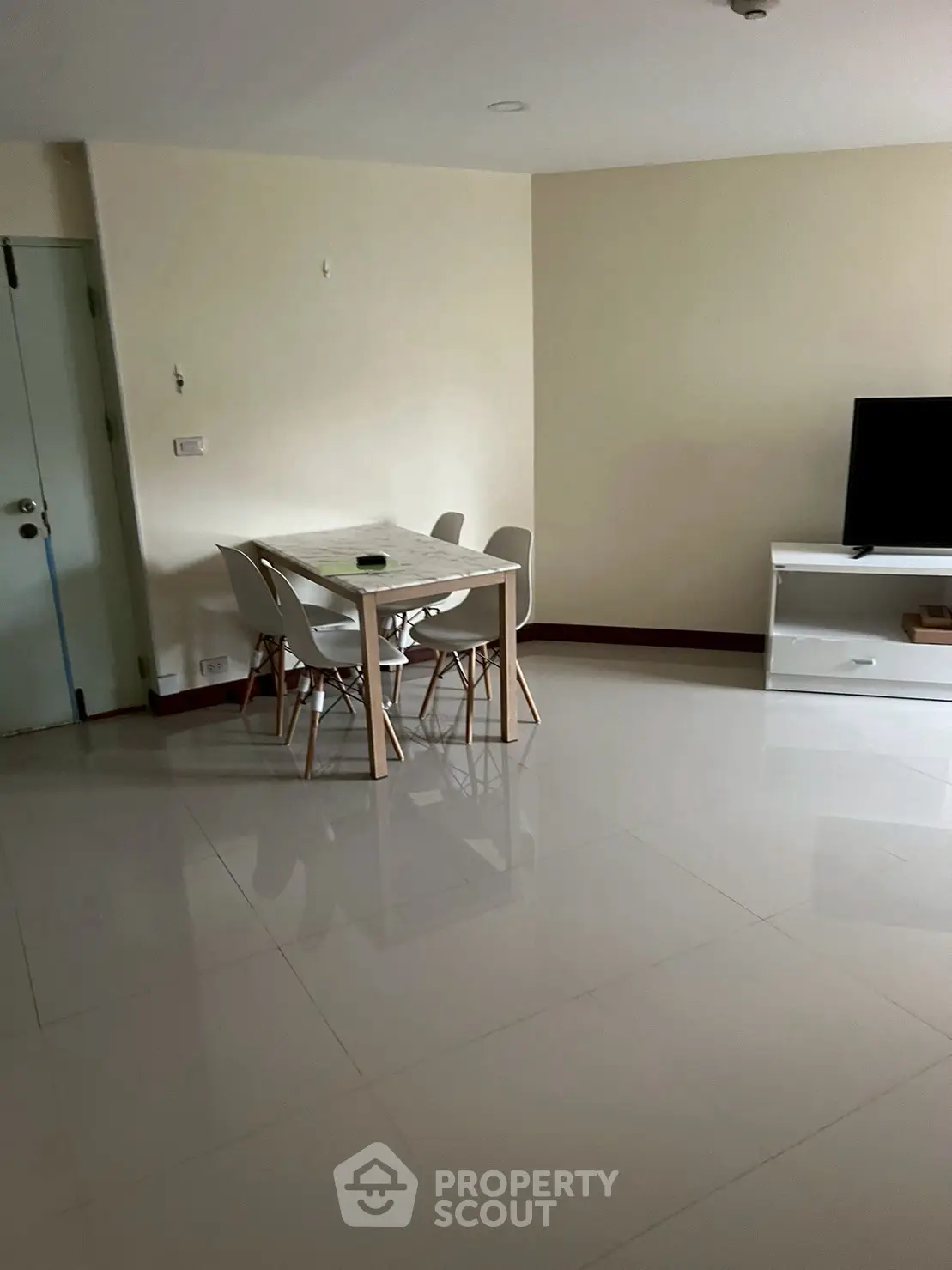Spacious living room with modern dining set and sleek TV stand.