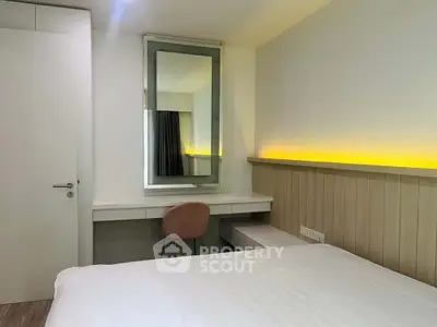 Modern bedroom with sleek design and ambient lighting, featuring a stylish desk and comfortable chair.