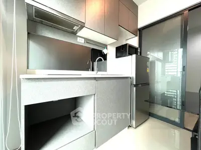 Modern kitchen with sleek cabinetry and stainless steel appliances in a contemporary apartment.