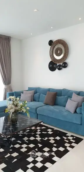Stylish living room with blue sofa, decorative wall art, and modern coffee table.