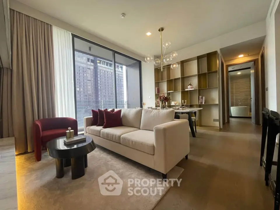 Modern living room with elegant decor and city view, featuring a cozy sofa and stylish dining area.