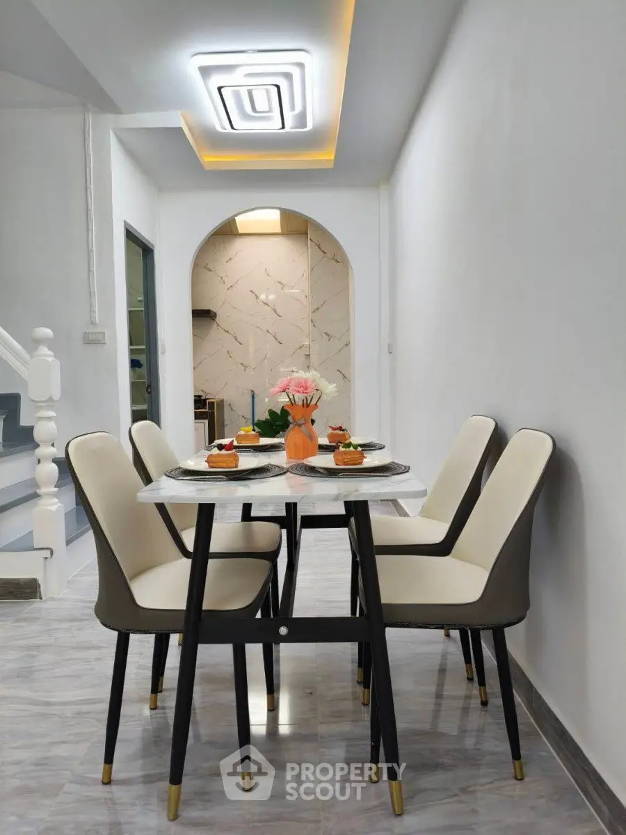 Modern dining area with elegant chairs and stylish ceiling light