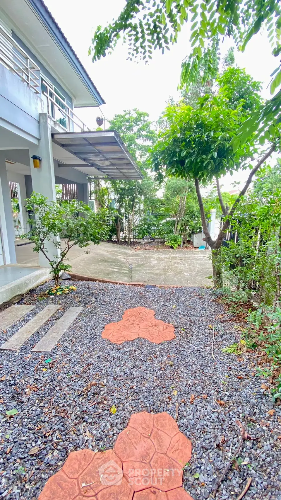 Charming garden pathway leading to a modern home with lush greenery and spacious outdoor area.