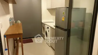 Modern compact kitchen with washing machine and fridge in cozy apartment