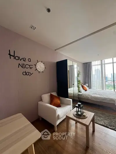Modern bedroom with city view, cozy seating area, and stylish decor for a welcoming atmosphere.