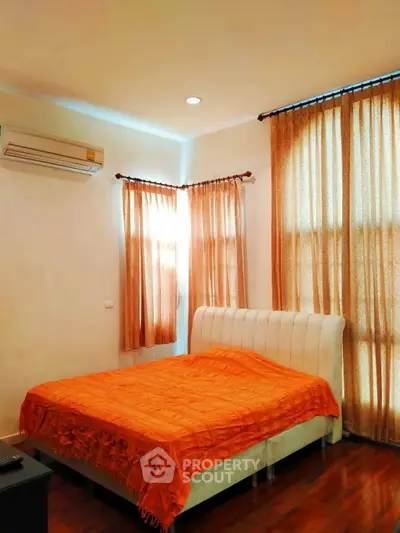 Cozy bedroom with orange accents and natural light