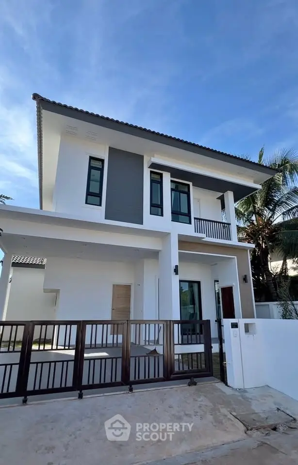 Modern two-story house with sleek design and gated entrance, perfect for contemporary living.