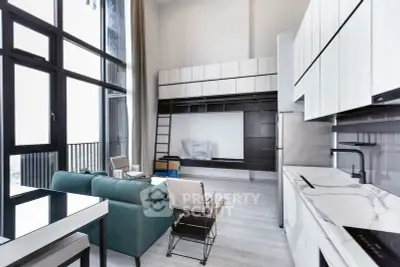 Modern open-plan living room with high ceilings and sleek kitchen design