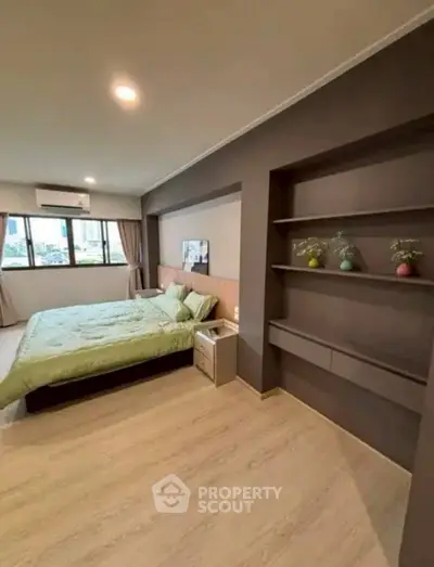 Spacious modern bedroom with built-in shelves and large window view.