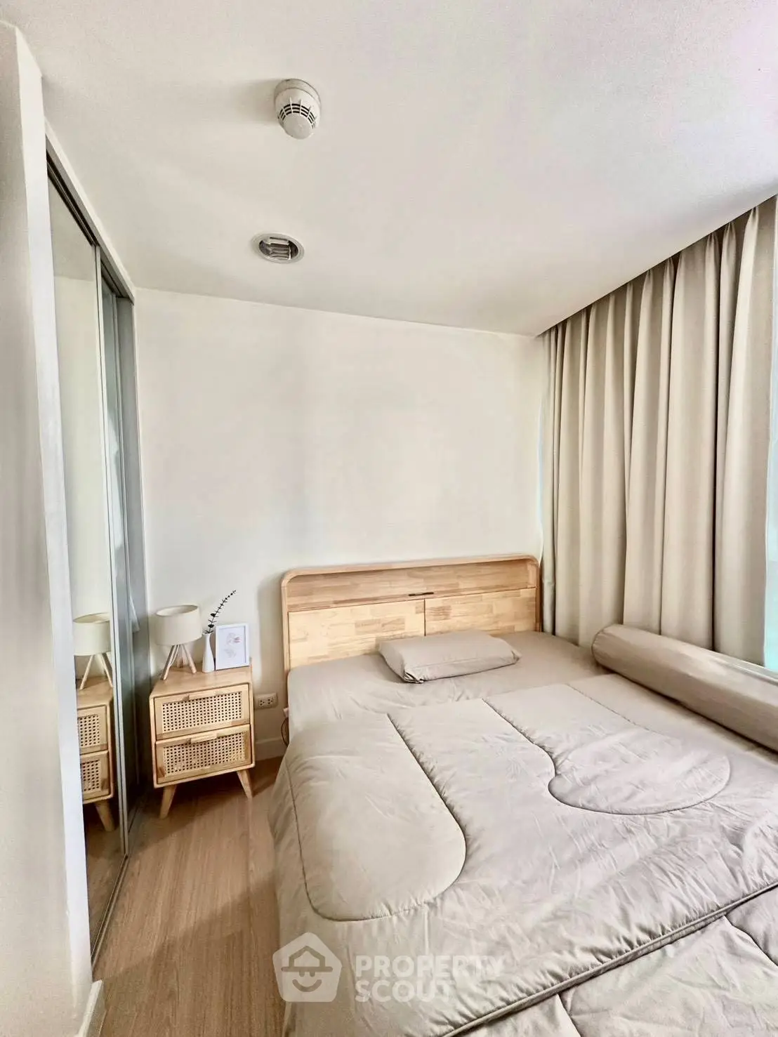 Modern bedroom with minimalist design and natural light, featuring a cozy bed and stylish wooden furniture.