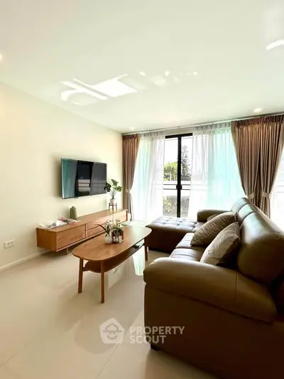 Spacious living room with modern decor and large windows for natural light.