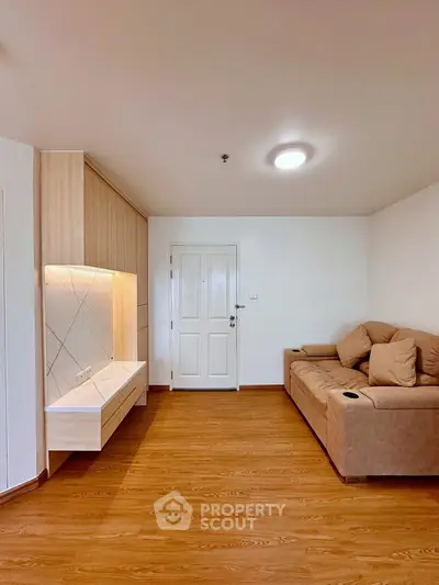 Modern living room with wooden flooring and cozy beige sofa