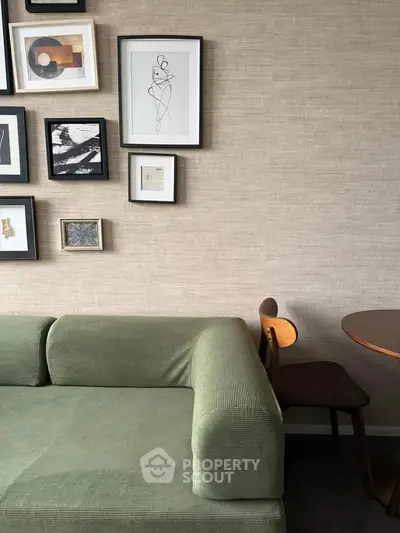 Stylish living room with green sofa and modern art on textured wall, perfect for contemporary urban living.