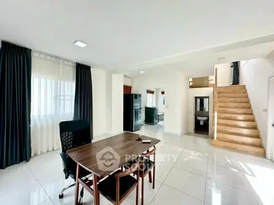 Spacious modern living area with sleek staircase and natural light