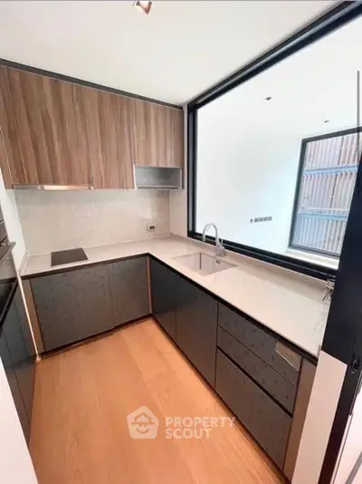Modern kitchen with sleek cabinetry and large window for natural light