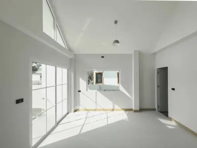 Spacious modern living room with high ceilings and large windows for natural light.